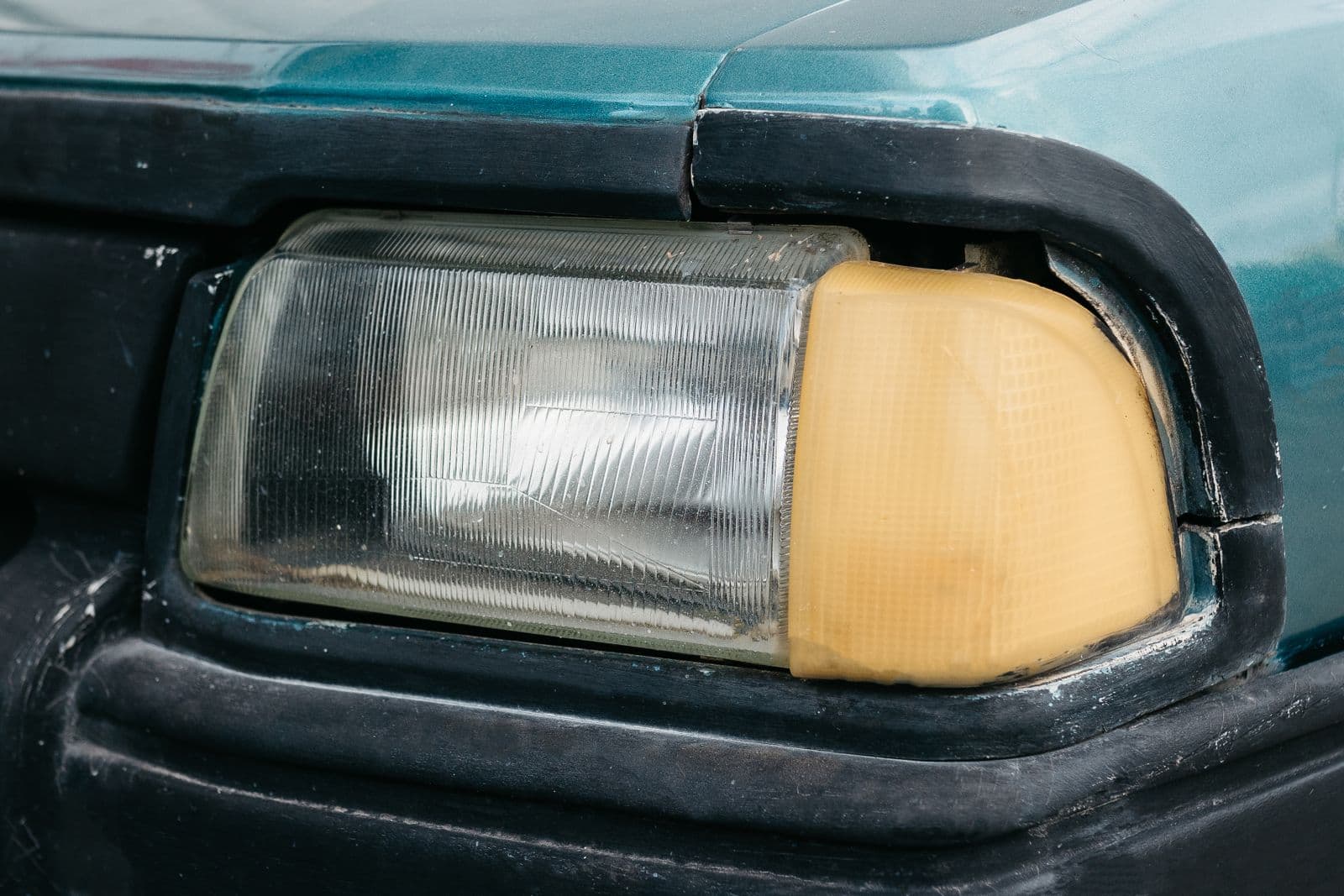 Phare de voiture avec partie du bloc optique jaunie et oxydée par le temps